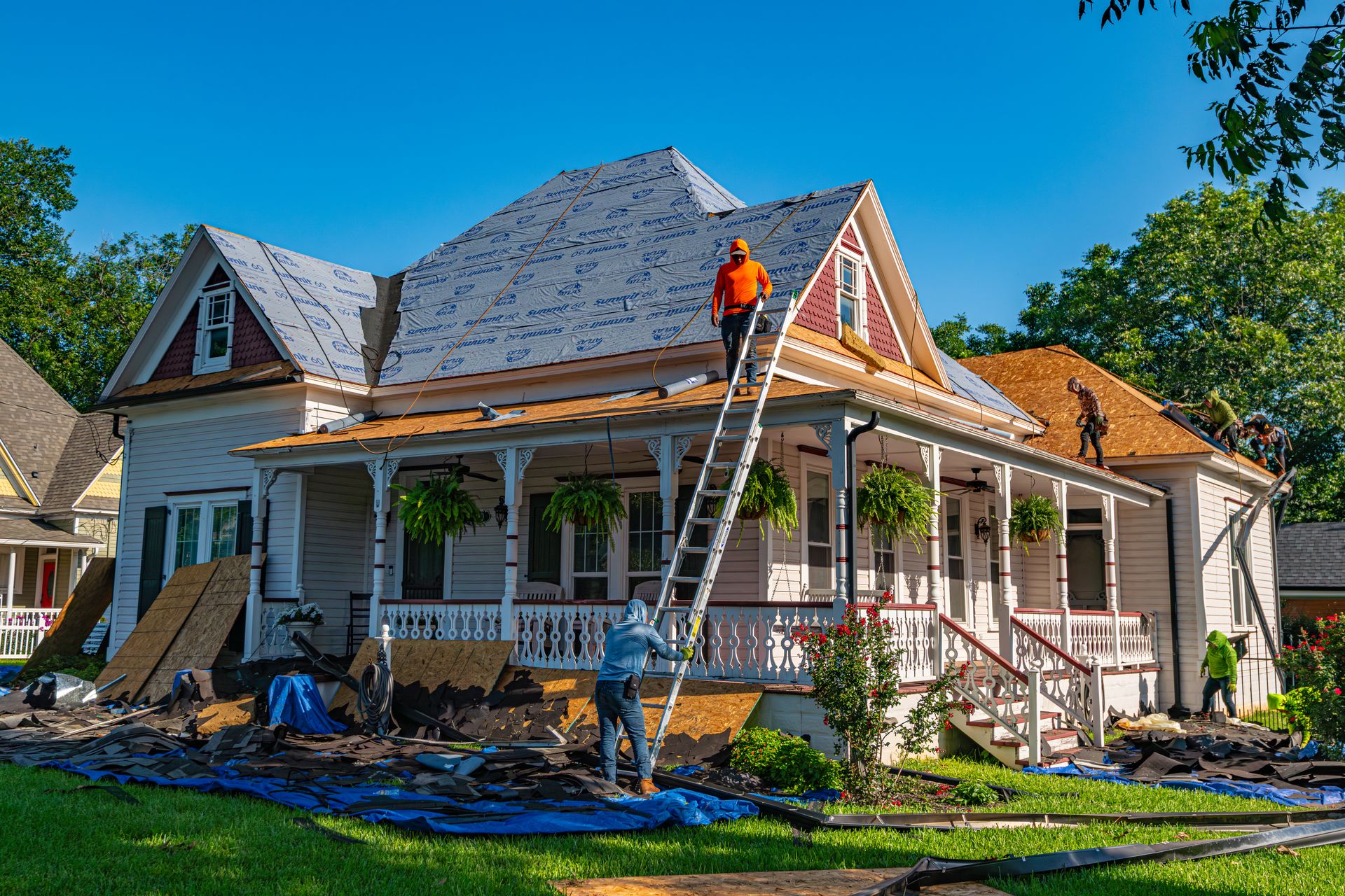 Crew replacing the roof of a house